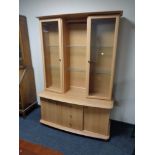 A display cabinet fitted double door cabinet and three drawers in pine finish