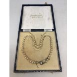 A boxed pearl necklace with clasp stamped 835