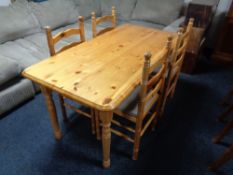 A pine rectangular kitchen table together with a set of four ladder backed chairs