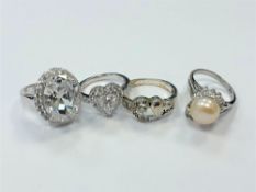 Four white metal dress rings