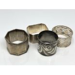 Four silver napkin rings including one Chinese showing a serpent