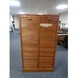 An Edwardian oak double shutter fronted music cabinet with key