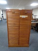 An Edwardian oak double shutter fronted music cabinet with key