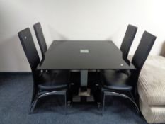 A contemporary black glass pedestal dining table together with four blank leather high backed