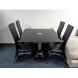 A contemporary black glass pedestal dining table together with four blank leather high backed