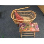 A wicker moses basket on wheels together with a bentwood stool