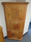 A blond oak triple door cabinet