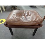A mid century footstool upholstered in brown leather