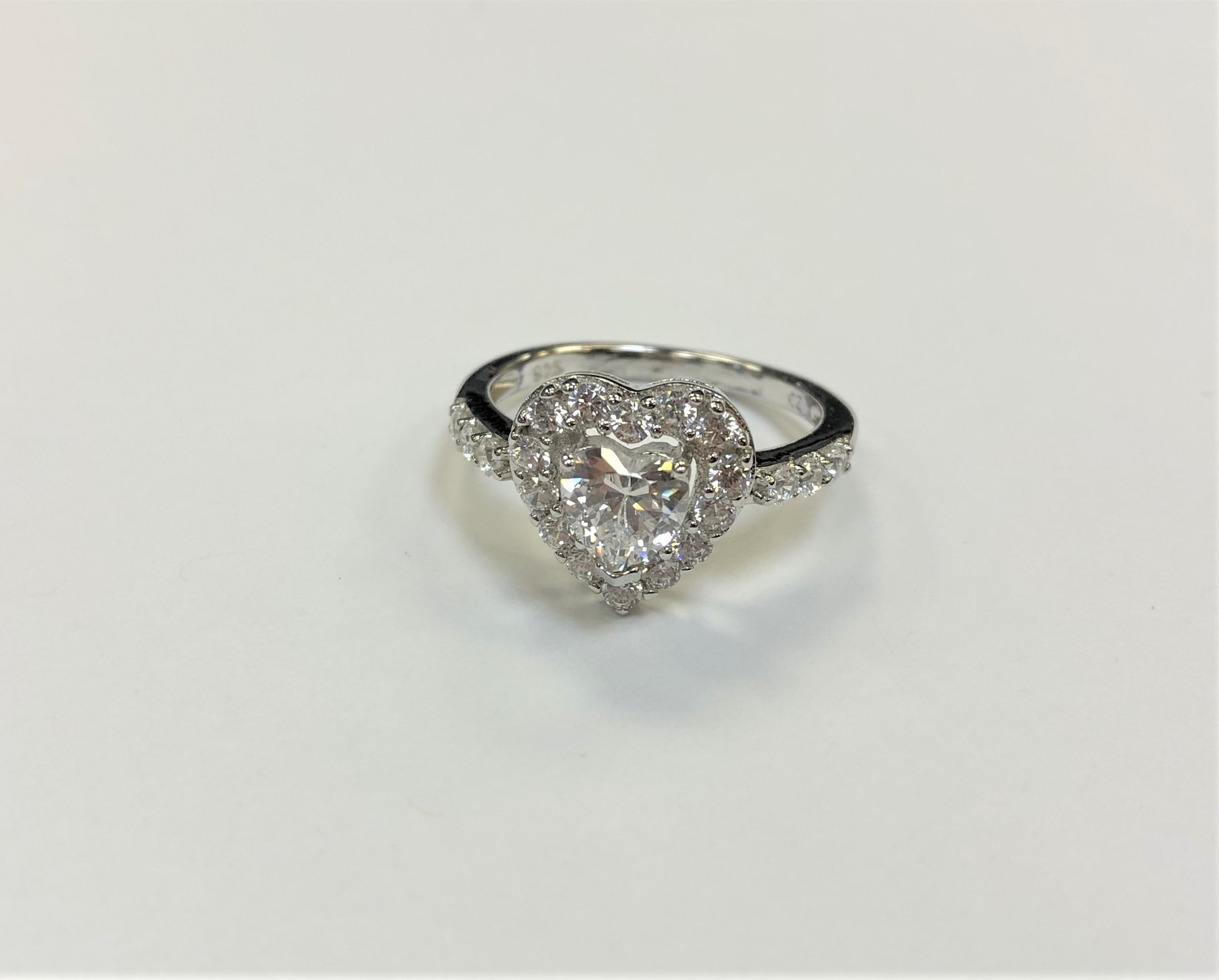 A white metal heart shaped dress ring,