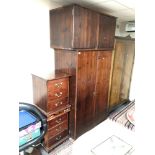 A stained pine double door wardrobe together with top box and pair of three drawer bedside chests