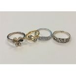 Four white metal dress rings