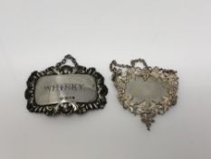 A silver Whisky decanter label and one other highly ornate silver label