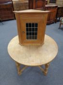 An oak leaded glass door corner cabinet together with circular blond oak coffee table