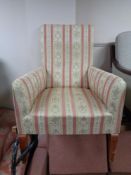 A fireside chair in Regency striped fabric