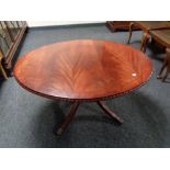 An inlaid mahogany oval pedestal coffee table