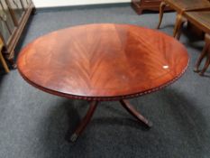 An inlaid mahogany oval pedestal coffee table