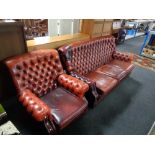 A red buttoned leather Chesterfield three seater settee with matching armchair