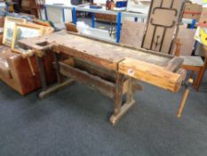 An early twentieth century wooden work bench fitted with two wooden vices