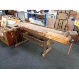 An early twentieth century wooden work bench fitted with two wooden vices