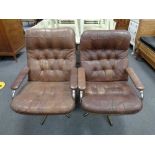 A pair of mid century Danish tubular metal swivel armchairs upholstered in brown leather