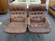 A pair of mid century Danish tubular metal swivel armchairs upholstered in brown leather