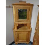 A blond oak double door corner cabinet