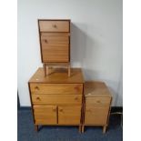 A mid century teak linen cabinet together with pair of cabinets fitted with a drawer