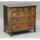 An 18th century oak and elm chest of drawers, fitted with two short and three long crossbanded