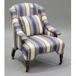 A late Victorian armchair, upholstered in striped fabric, raised on turned legs and castors,