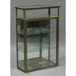 An early 20th century brass framed and glazed display cabinet, fitted with glass shelves and a