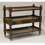 An early Victorian mahogany three-tier buffet with reeded supports, on turned feet with brass caps