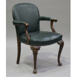 An early 20th century walnut framed library elbow chair, upholstered in green leather, raised on