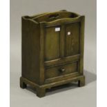 A late 20th century Jacobean style oak magazine rack, fitted with a drawer, on bracket feet,