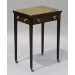 A small Regency mahogany fold-over tea table, fitted with brass handles, raised on square tapering