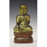 A South-east Asian gilt and lacquered wood figure of Buddha, probably Burmese, modelled seated in