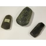 A group of three Swiss Neolithic polished stone axe heads, one bearing 'F.S. Clark Collection'