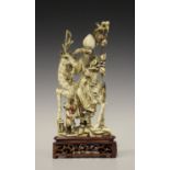 A Chinese carved and stained ivory figure group, early 20th century, modelled as Shoulao seated on a