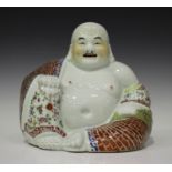 A Chinese famille rose porcelain figure of a smiling Buddha, early 20th century, modelled seated