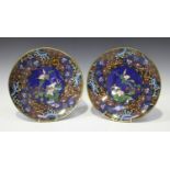 A pair of Japanese cloisonné circular dishes, Meiji period, each central blue ground floral panel