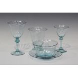 A part suite of sky blue tinted glass tableware, in the style of James Powell, comprising six wines,
