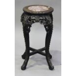 A Chinese hardwood stand, late 19th century, the circular top inset with a rouge marble panel