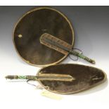 A pair of late 19th/early 20th century Zulu animal hide circular fans, the handles bound in leather,