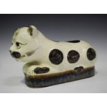 A Chinese cream glazed pottery pillow, 20th century, of recumbent cat form with dark brown painted