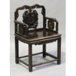 A Chinese hardwood armchair, late Qing dynasty, the shaped top rail carved with a bat, supporting