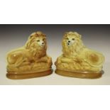 Two pairs of Staffordshire pottery lions, late 19th/early 20th century, inset with glass eyes, one