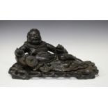 A Chinese carved hardwood figure of the immortal Liu Hai, early 20th century, modelled recumbent,