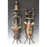 Two similar Senufo carved and painted wooden masks, Ivory Coast, both modelled with figural