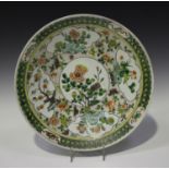 A Chinese famille verte porcelain circular dish, late 19th/early 20th century, painted with panels