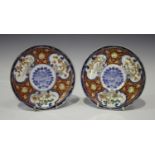 A pair of Japanese Imari porcelain circular side dishes, Meiji period, painted with panels of pine