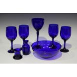 A small group of Bristol blue glassware, 20th century, including four wines and a bowl.Buyer’s